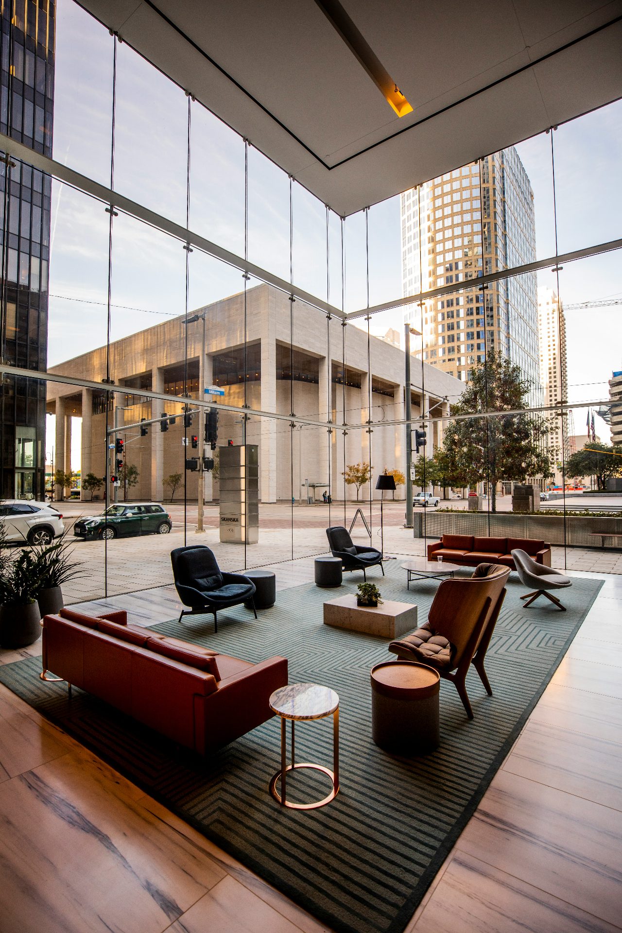 Modern hotel lobby with floor-to-ceiling windows overlooking a Nordic downtown plaza