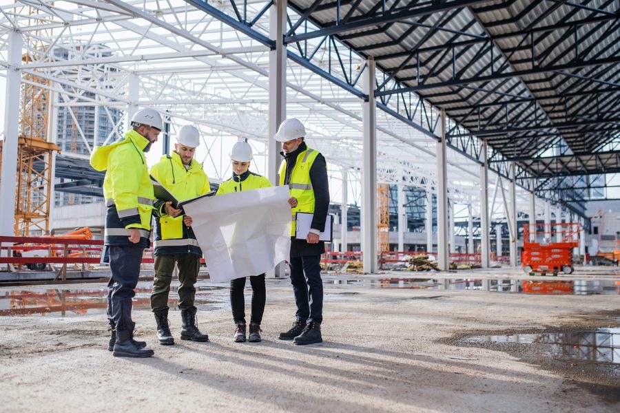 Construction team reviewing hotel project blueprints on site